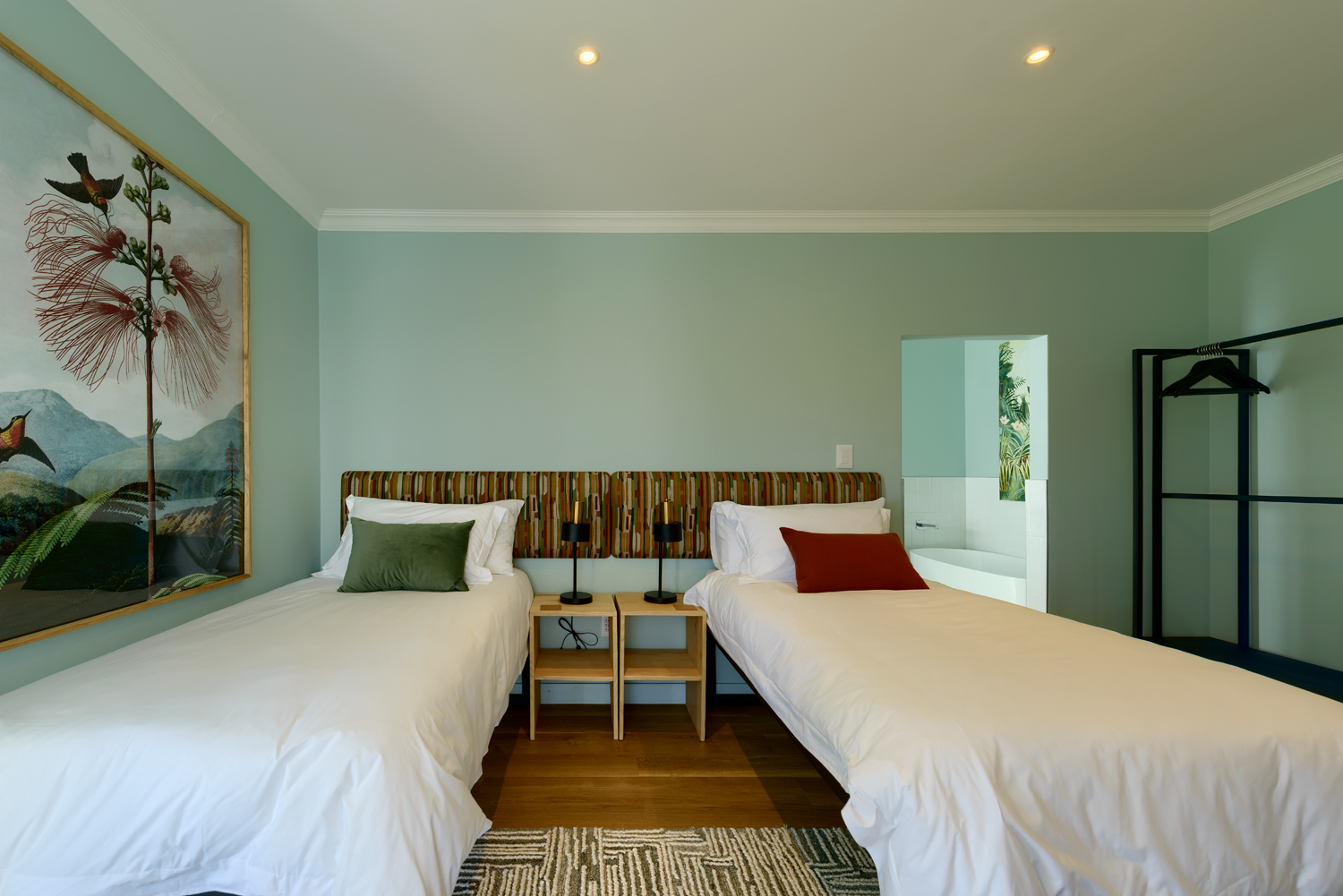 A neatly made bed with white linens in a cozy, softly lit bedroom.